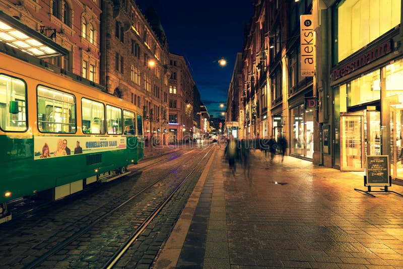 Tram verde che passa per la via della spesa della città di helsinki fotografia stock