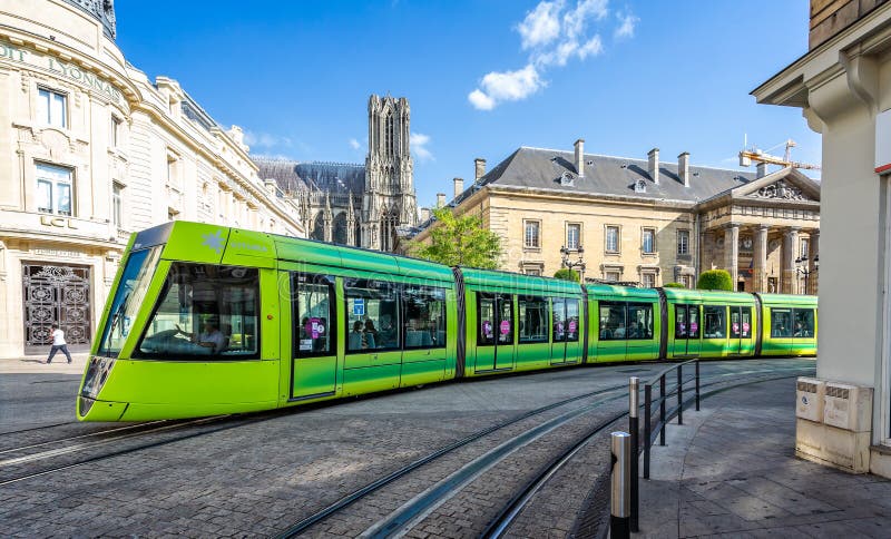 Tram verde Flourescent che passa davanti alla cattedrale di Reims fotografia stock