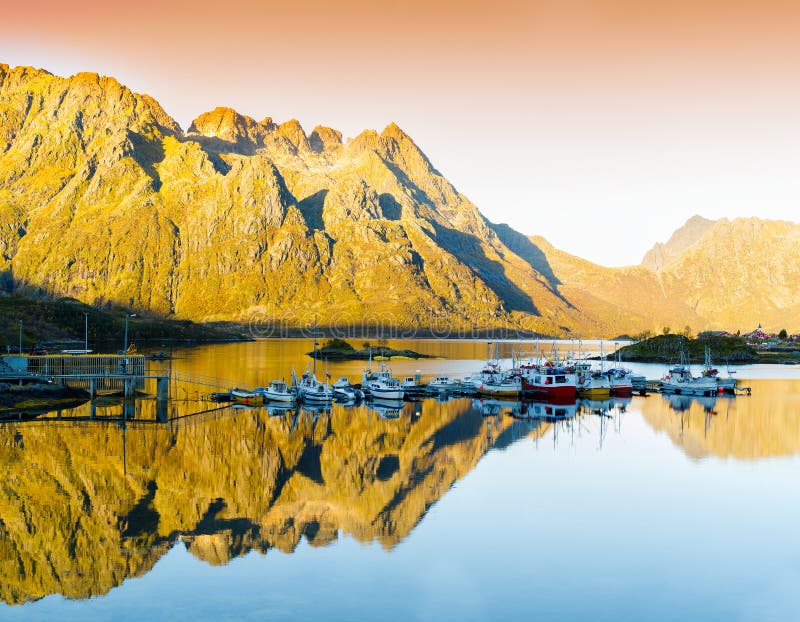 Tramonto arancio vivo orizzontale nelle terre di riflessione dei fiordi della Norvegia fotografia stock Tramonto arancio vivo orizzontale nelle terre di riflessione dei fiordi della Norvegia fotografia stock