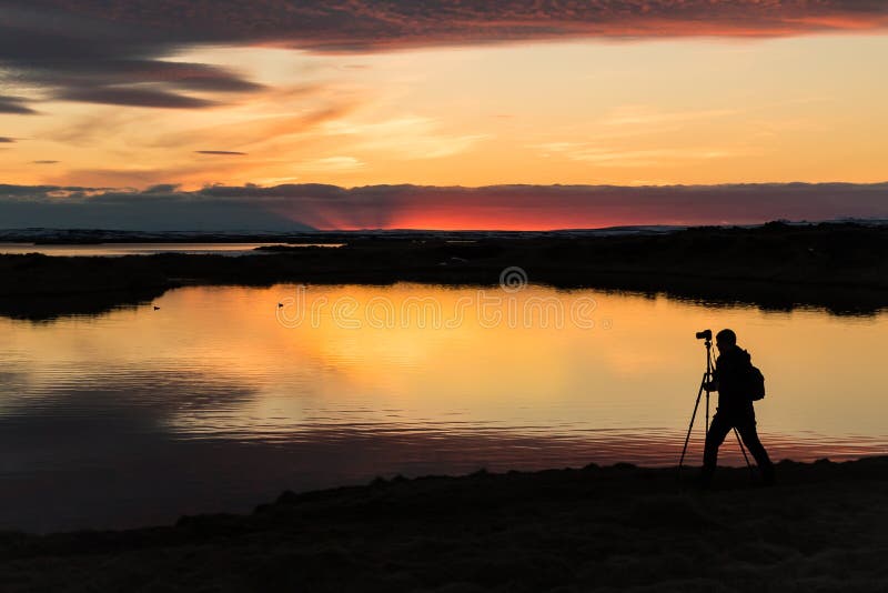 Tramonto con una siluetta di un cineoperatore a Myvatn Islanda immagine stock Tramonto con una siluetta di un cineoperatore a Myvatn Islanda immagine stock