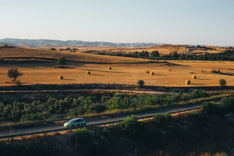 Tramonto dorato sopra il campo dell'azienda agricola con le balle di fieno fotografia stock libera da diritti Tramonto dorato sopra il campo dell'azienda agricola con le balle di fieno fotografia stock libera da diritti