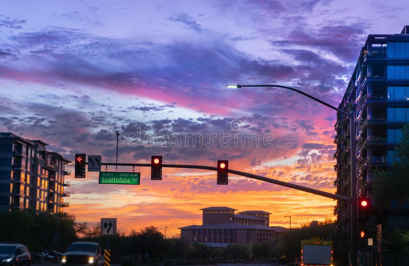 Tramonto drammatico a Scottsdale del nord, Arizona Le automobili guidano tramite un'intersezione occupata su Scottsdale rd e sul fotografia stock Tramonto drammatico a Scottsdale del nord, Arizona Le automobili guidano tramite un'intersezione occupata su Scottsdale rd e sul fotografia stock