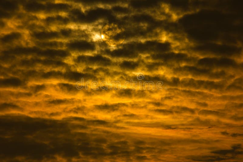 Tramonto o alba drammatico con il cielo dorato e le nuvole nere che formano un estratto con il sole nei precedenti immagine stock libera da diritti Tramonto o alba drammatico con il cielo dorato e le nuvole nere che formano un estratto con il sole nei precedenti immagine stock libera da diritti