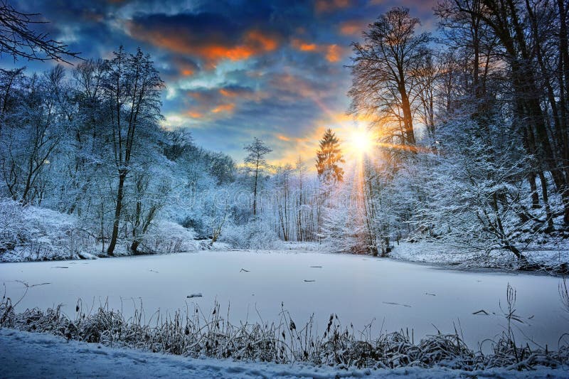 Tramonto sopra il lago della foresta di inverno immagini stock