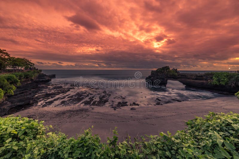Tramonto stupendo sulla costa rocciosa di Pura Batu Bolong, Tempio di Tanah Lot, Bali, Indonesia fotografia stock Tramonto stupendo sulla costa rocciosa di Pura Batu Bolong, Tempio di Tanah Lot, Bali, Indonesia fotografia stock