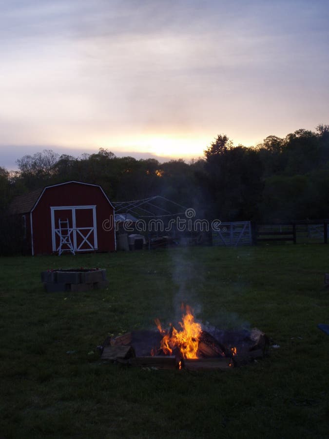 Tramonto in una fattoria rurale con fuoco da campeggio
