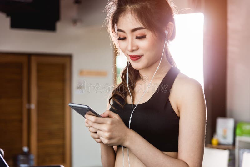 Trampkvarn för livsstil för ung kvinna rinnande genom att använda den smarta mobiltelefonen arkivfoto Trampkvarn för livsstil för ung kvinna rinnande genom att använda den smarta mobiltelefonen arkivfoto