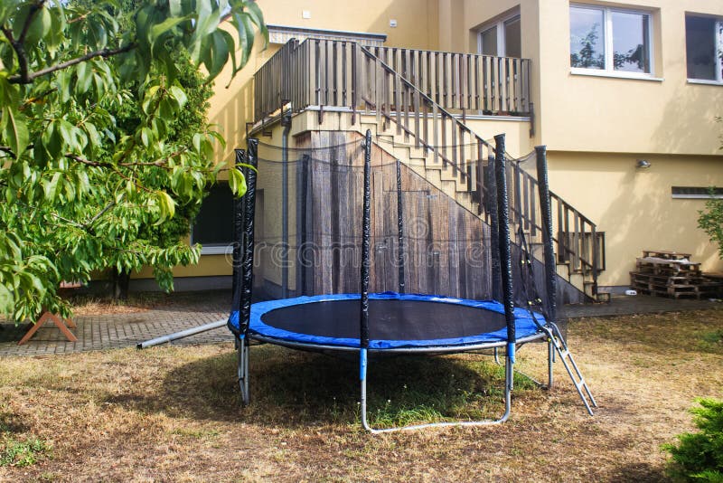 Trampolin Mit Sicherheitsnetz Auf Dem Rasen in Einem Garten. Stockfoto -  Bild von athletisch, ausrüstung: 208713696