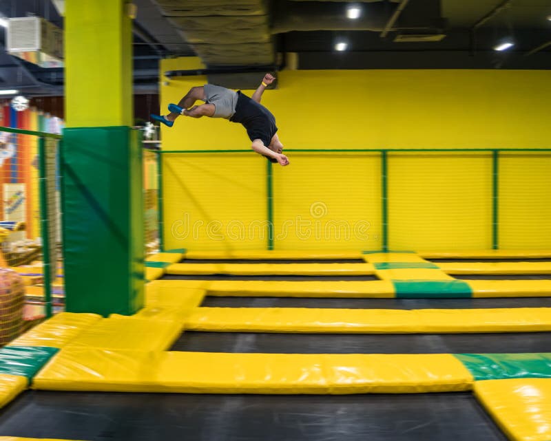 Trampolinepullover führt akrobatische Übungen auf der Trampoline durch stockfotografie Trampolinepullover führt akrobatische Übungen auf der Trampoline durch stockfotografie