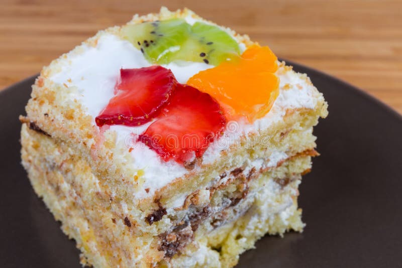 Tranche de gâteau mousseline posé avec le plan rapproché de décoration de fruits photos libres de droits Tranche de gâteau mousseline posé avec le plan rapproché de décoration de fruits photos libres de droits