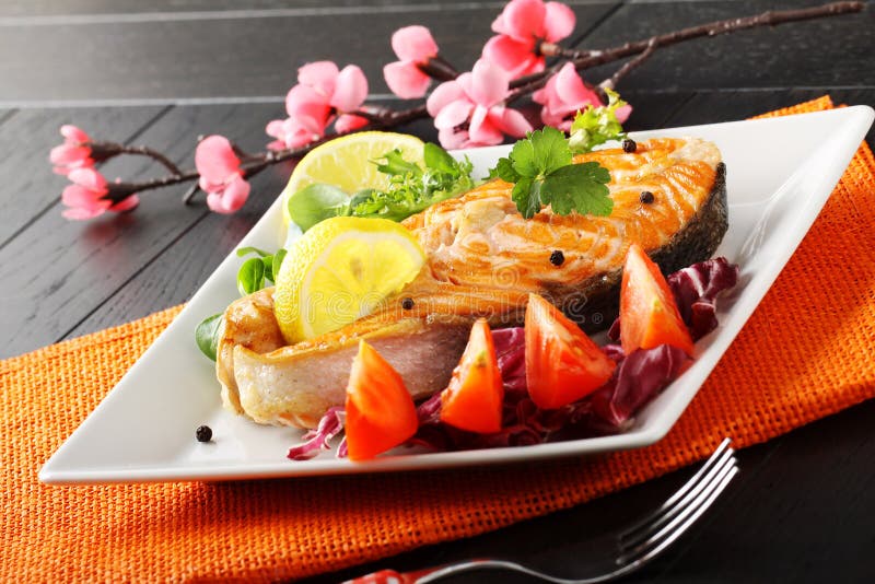 Slice of fresh salmon with tomatoes and salad on complex background. Slice of fresh salmon with tomatoes and salad on complex background