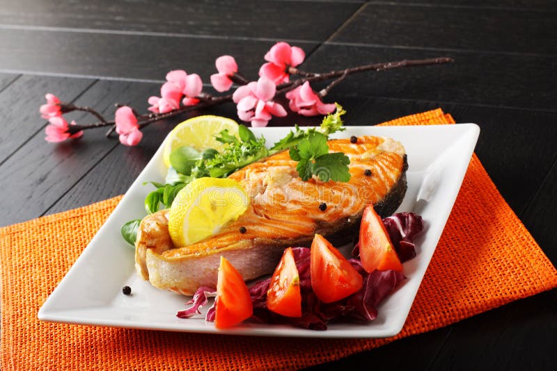 Slice of fresh salmon with tomatoes and salad on complex background. Slice of fresh salmon with tomatoes and salad on complex background