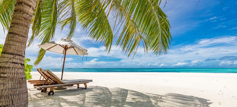 Tranquil beach scene. Panoramic tropical beach landscape for background or wallpaper, two lounge chairs with umbrella