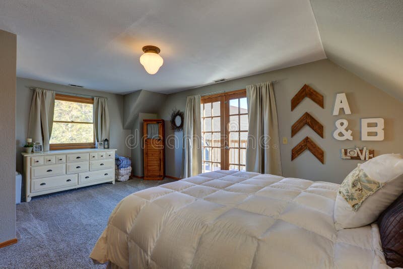 Tranquil Bedroom With Sloped Ceiling And Doors To Nice Deck