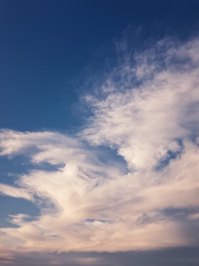 Tranquil evening cloudscape scene over the blue sky. Fluffy white clouds aerial composition. Misty overcast cumulus shapes royalty free stock photo