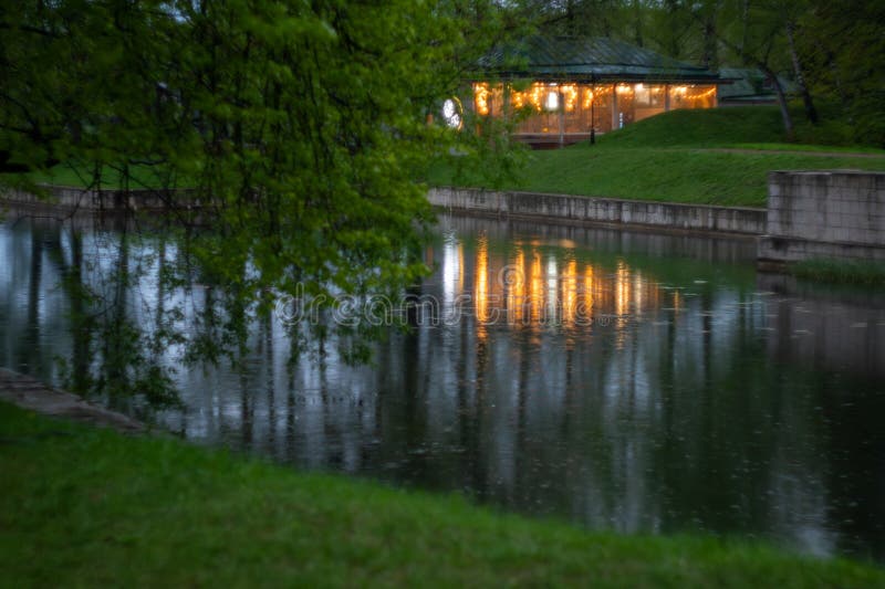 Tranquil evening at riverside with illuminated building reflection stock images