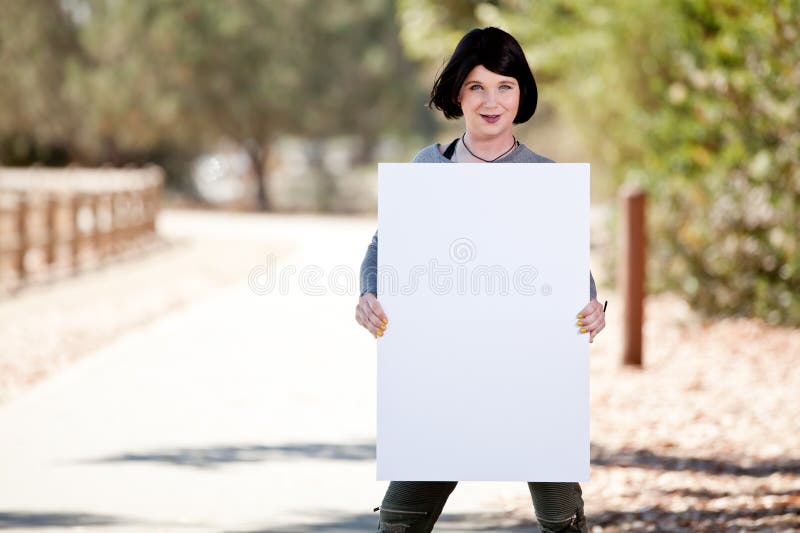 Transexual con la muestra en blanco del tablero del cartel imagen de archivo libre de regalías Transexual con la muestra en blanco del tablero del cartel imagen de archivo libre de regalías