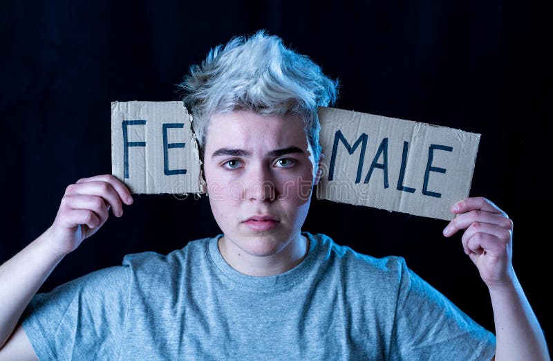 Transgender teenager breaking the word FEMALE into MALE. Gender identity and human rights concept royalty free stock photography Transgender teenager breaking the word FEMALE into MALE. Gender identity and human rights concept royalty free stock photography