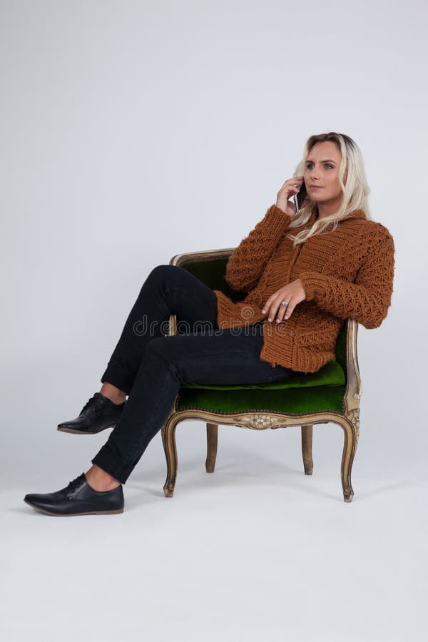 Transgender Using Mobile Phone While Sitting On Chair