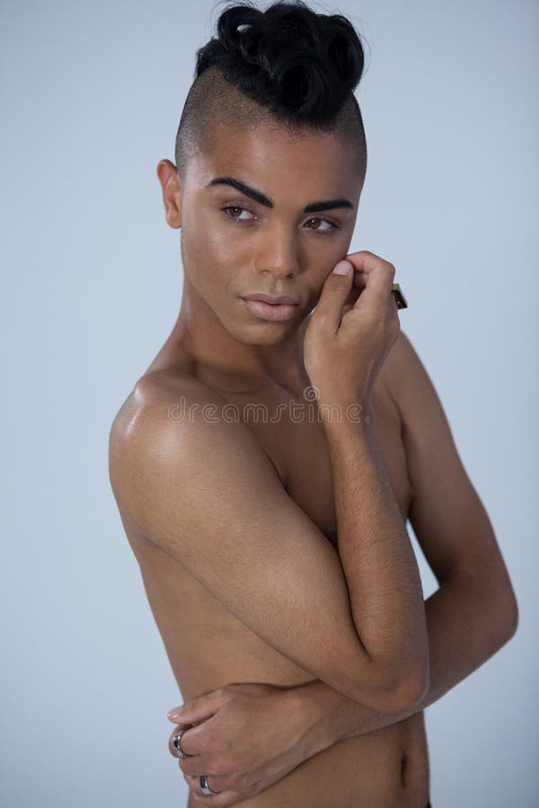 Transgender woman looking away while standing over gray background stock ph...