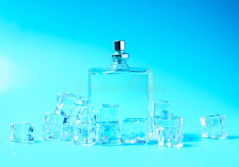 Transparent perfume bottle and ice cubes stock photography