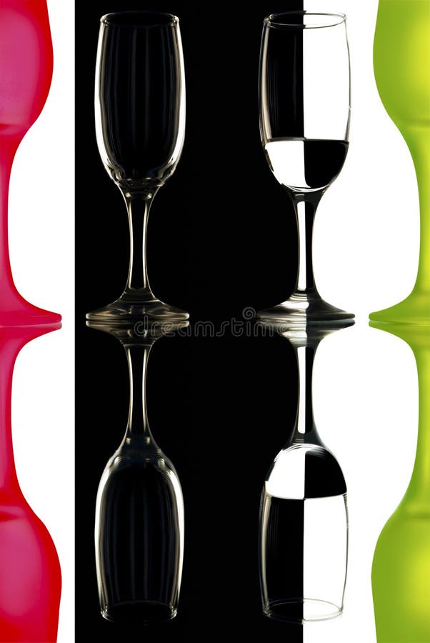 Transparent and the red-green wine glasses on the black-and-white background with reflection.