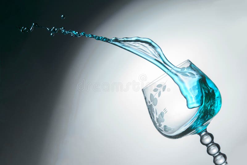 Transparentes Glas mit einem blauen Jet der Flüssigkeit oben, Nahaufnahme stockfoto Transparentes Glas mit einem blauen Jet der Flüssigkeit oben, Nahaufnahme stockfoto