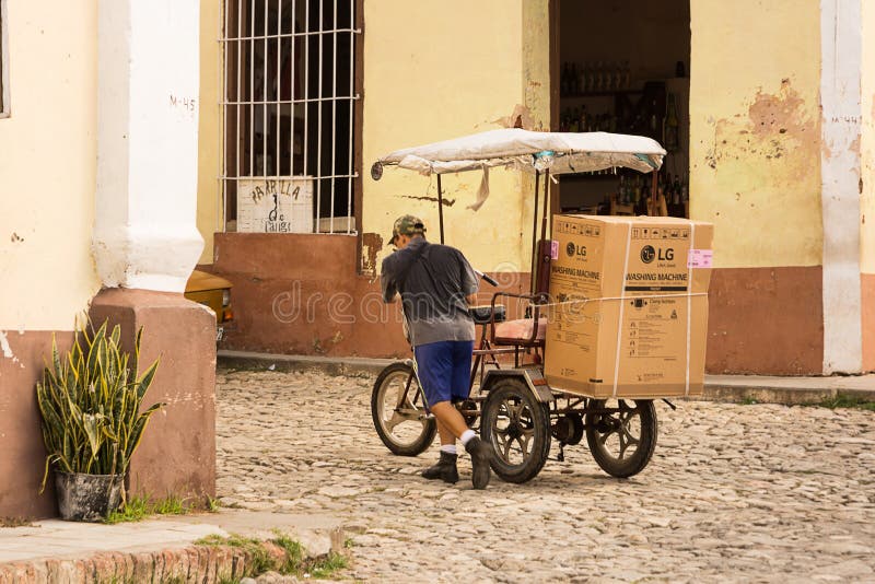 Transportation of a modern washing machine with a bicycle in Trinidad, Cuba. stock photography Transportation of a modern washing machine with a bicycle in Trinidad, Cuba. stock photography