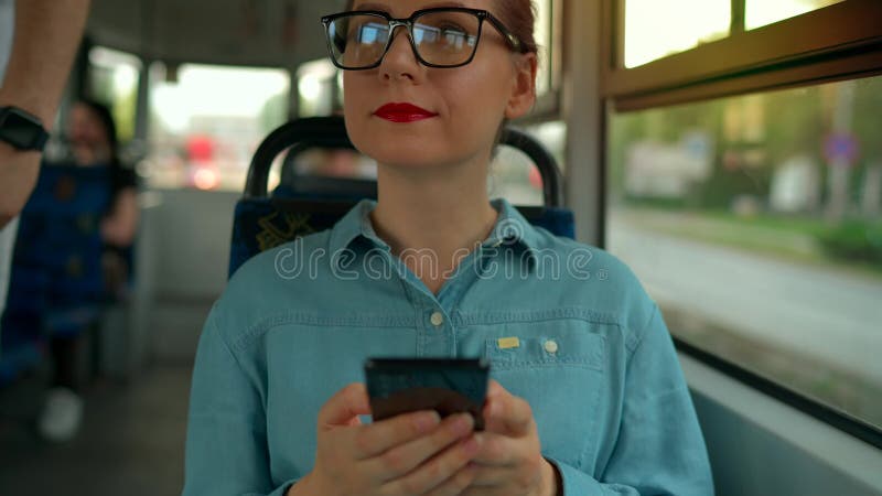 Transporte público. Mujer con gafas en tranvía usando smartphone. almacen de metraje de vídeo