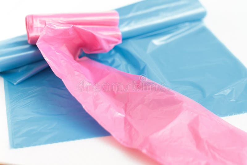 Two trash bags in blue and pink isolated on white studio background.