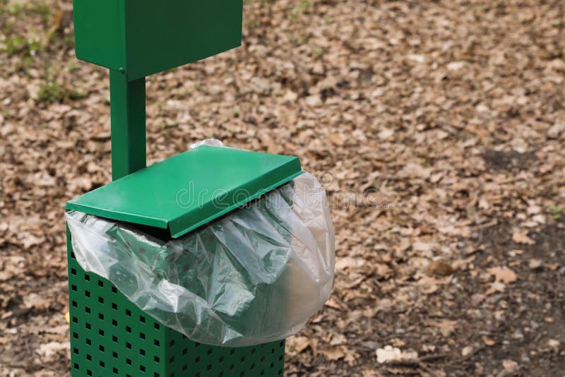 Trash Bin with Plastic Bag in Park. Space for Text Stock Photo Image