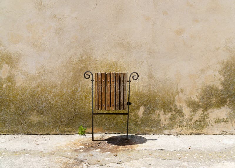 Trashcan ao lado de uma planta emergente na frente de uma parede aborrecido - espaço da cópia imagens de stock royalty free Trashcan ao lado de uma planta emergente na frente de uma parede aborrecido - espaço da cópia imagens de stock royalty free
