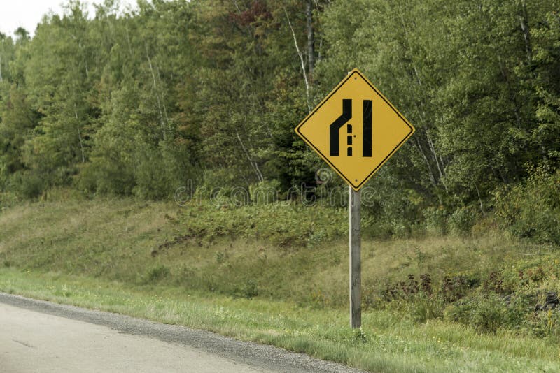 Trasporto stretto Canada della Quebec del nero di giallo della posta del segnale stradale davanti alla foresta fotografie stock Trasporto stretto Canada della Quebec del nero di giallo della posta del segnale stradale davanti alla foresta fotografie stock