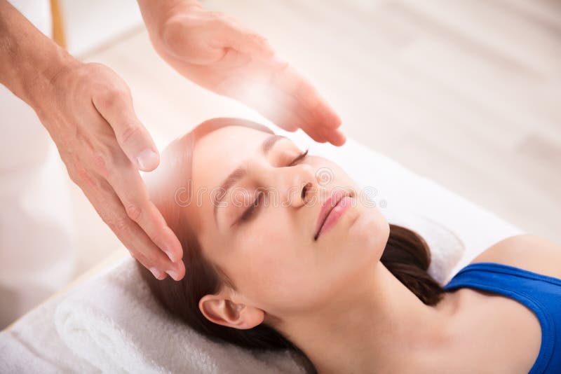 Tratamento de Performing Reiki Healing do terapeuta na mulher imagens de stock Tratamento de Performing Reiki Healing do terapeuta na mulher imagens de stock