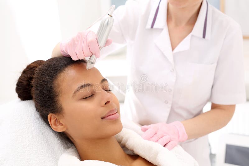 Beautician performs a needle mesotherapy treatment on a woman`s face. Beautician performs a needle mesotherapy treatment on a woman`s face