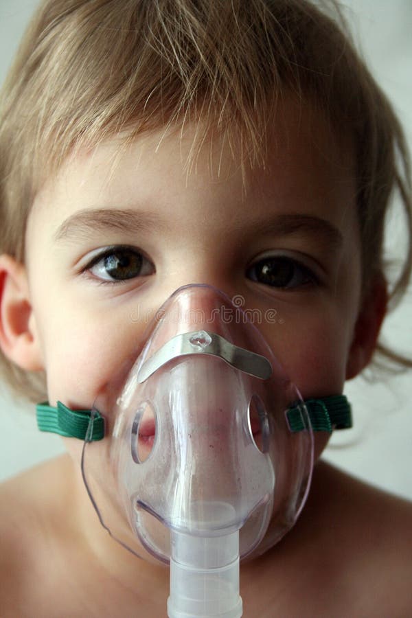 A little girl looks at the camera while taking her nebulizer breathing treatment. A little girl looks at the camera while taking her nebulizer breathing treatment.