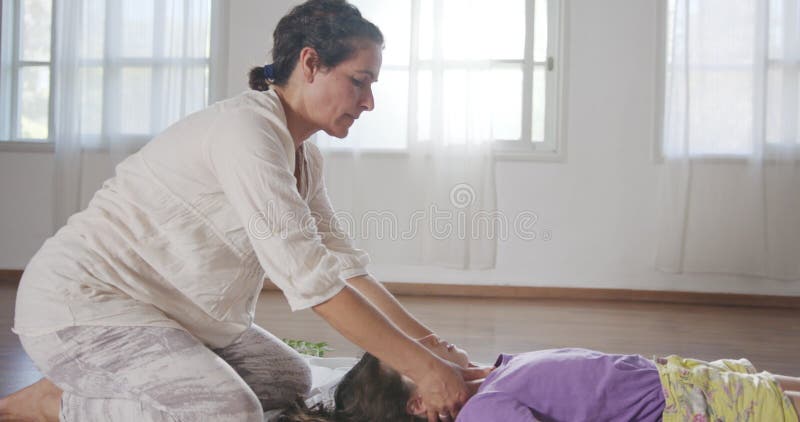 Tratamiento shiatsu. masajista que da tratamiento a una joven con diferentes métodos. almacen de metraje de vídeo