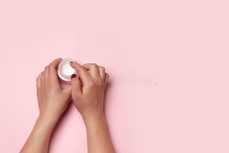 Tratamientos de la belleza Las manos femeninas sostienen un tarro de cristal con una crema o un skincare cosmético y manchan sus imagen de archivo libre de regalías Tratamientos de la belleza Las manos femeninas sostienen un tarro de cristal con una crema o un skincare cosmético y manchan sus imagen de archivo libre de regalías