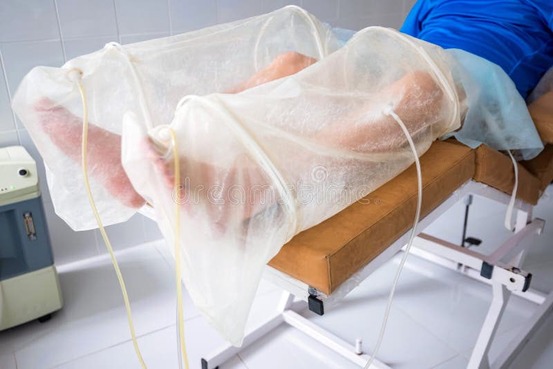 Close up male`s legs in white bags on medical couch getting ozone therapy treatment. Close up male`s legs in white bags on medical couch getting ozone therapy treatment