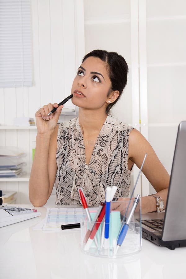 Sad, pensive and dreaming young woman sitting in the office. Concept for problems at work. Sad, pensive and dreaming young woman sitting in the office. Concept for problems at work.