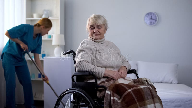 Traurige Frau ins Krankenhaushausmeister-Reinigungsraum des Rollstuhls aufpassendem, Gesundheitszentrum lizenzfreies stockbild Traurige Frau ins Krankenhaushausmeister-Reinigungsraum des Rollstuhls aufpassendem, Gesundheitszentrum lizenzfreies stockbild