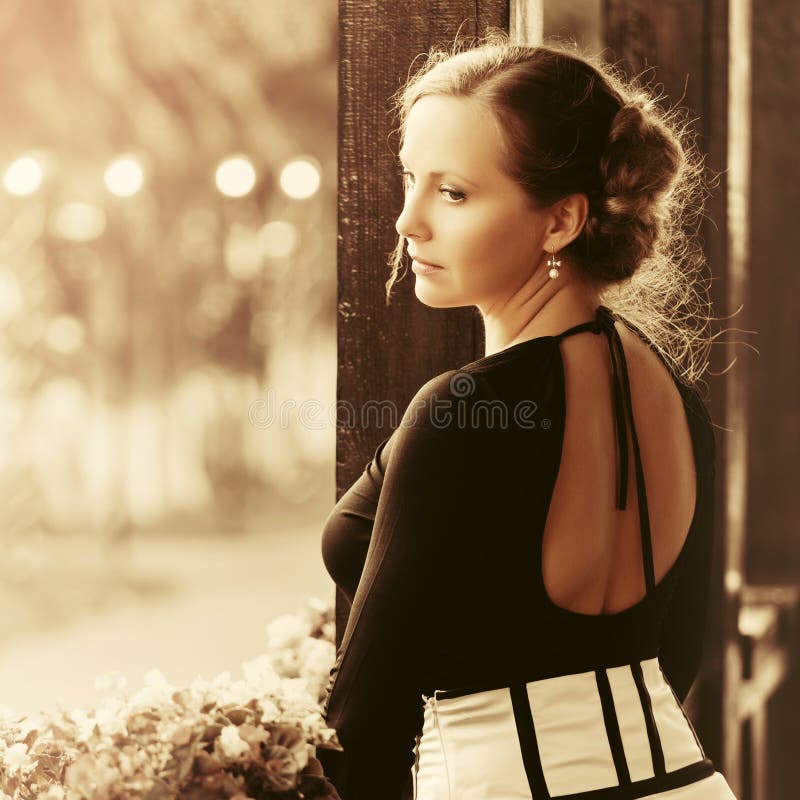 Traurige schöne Modefrau mit Brötchen updo Haarstellung auf Portal stockbilder Traurige schöne Modefrau mit Brötchen updo Haarstellung auf Portal stockbilder