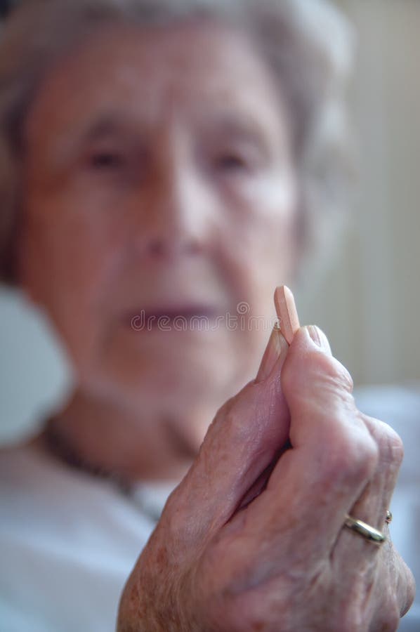 Traurige ältere Frau, die Pille nimmt lizenzfreies stockfoto Traurige ältere Frau, die Pille nimmt lizenzfreies stockfoto