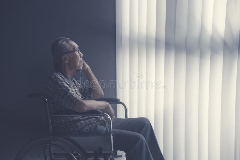 Trauriger einsamer älterer Mann, der auf Rollstuhl sitzt