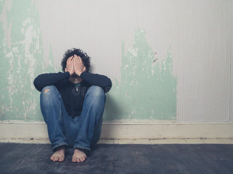 Trauriger junger Mann im leeren Raum lizenzfreies stockbild Trauriger junger Mann im leeren Raum lizenzfreies stockbild