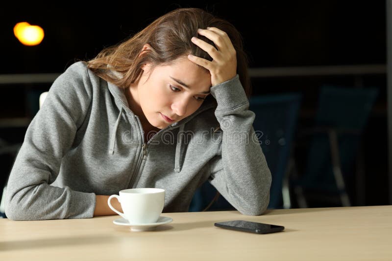 Trauriges jugendlich, auf eine telefonische Mitteilung in einer Stange wartend stockfotos Trauriges jugendlich, auf eine telefonische Mitteilung in einer Stange wartend stockfotos