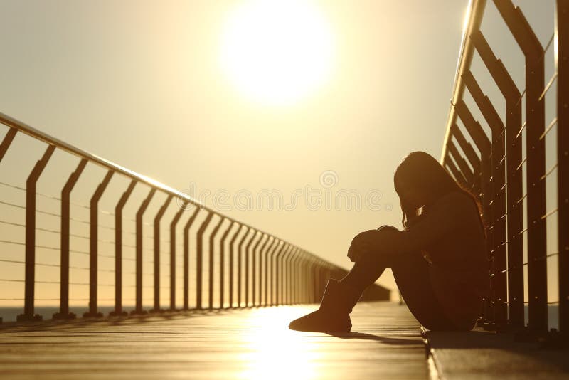 Trauriges Jugendlichmädchen drückte das Sitzen in einer Brücke bei Sonnenuntergang nieder stockfotografie Trauriges Jugendlichmädchen drückte das Sitzen in einer Brücke bei Sonnenuntergang nieder stockfotografie