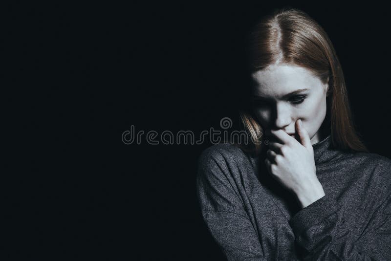 Trauriges Mädchen gegen schwarze Wand stockbild Trauriges Mädchen gegen schwarze Wand stockbild