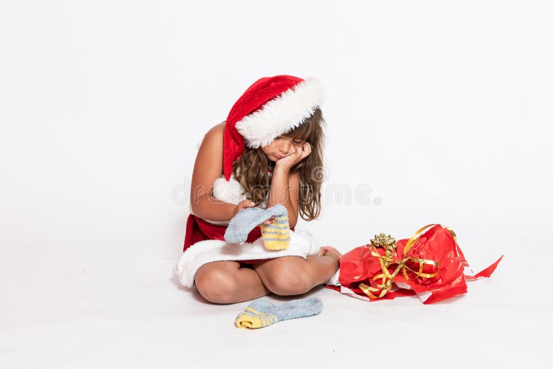 Trauriges Mädchen in Santa Claus-Kostüm mit ungeeignetem Geschenk stockfotos Trauriges Mädchen in Santa Claus-Kostüm mit ungeeignetem Geschenk stockfotos