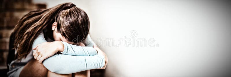 Trauriges Schulmädchen, das allein auf Treppenhaus sitzt stockfotografie Trauriges Schulmädchen, das allein auf Treppenhaus sitzt stockfotografie